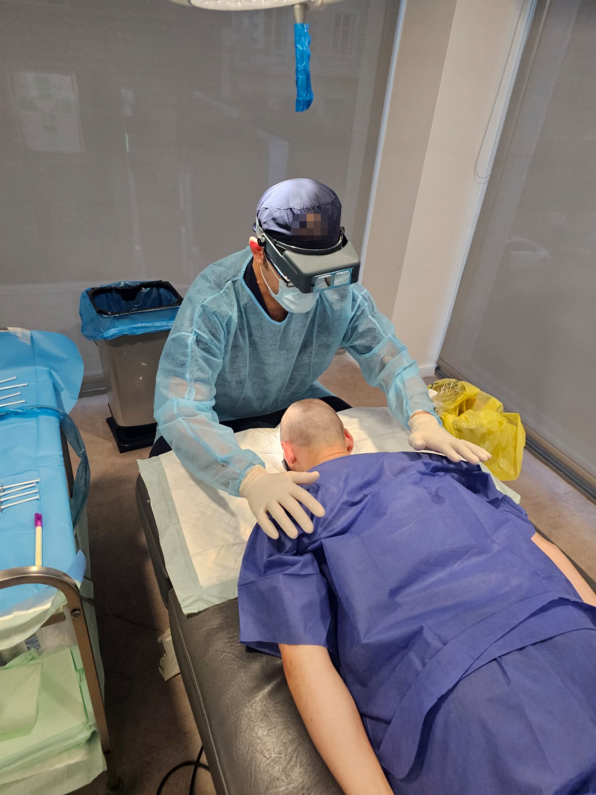 Arzt mit Lupenbrille während der Behandlung